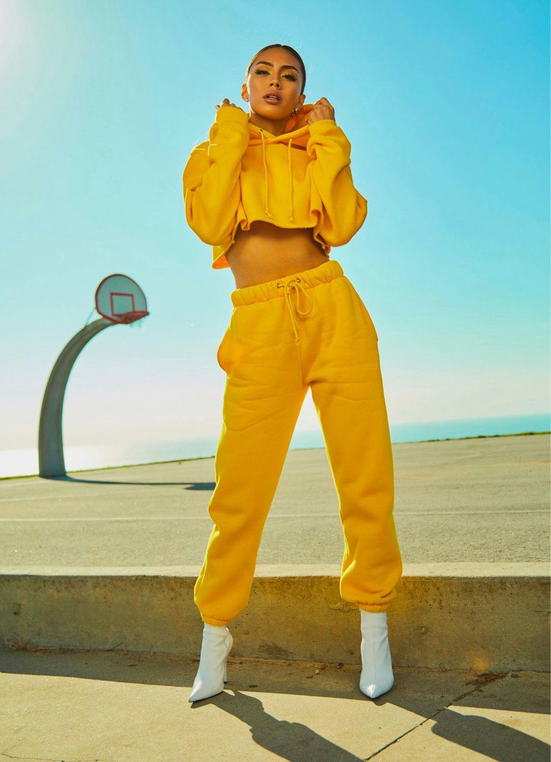 A fashion model wearing yellow hoodie and sweats